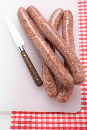 simsearch:659-02211855,k - Four sausages on chopping board with knife Fotografie stock - Premium Royalty-Free, Codice: 659-01867456