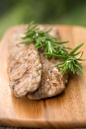 Fried pork sausagemeat with rosemary on chopping board Stock Photo - Premium Royalty-Free, Code: 659-01867492