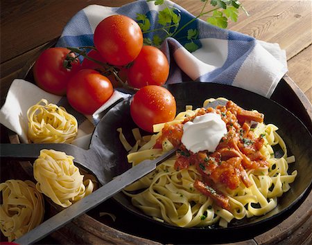 Pasta with tomato & sausage sauce and crème fraîche in pan Stock Photo - Premium Royalty-Free, Code: 659-01867508