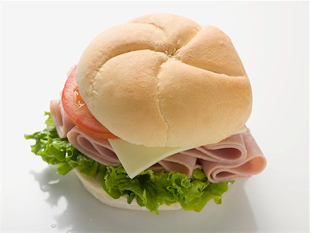 Bread roll filled with ham, cheese, lettuce and tomato Stock Photo - Premium Royalty-Free, Code: 659-01867555