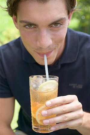 Jeune homme boire du thé glacé avec une paille Photographie de stock - Premium Libres de Droits, Code: 659-01867636