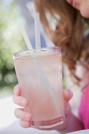 Woman holding a glass of lemonade with straws Stock Photo - Premium Royalty-Free, Code: 659-01867680