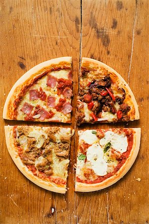 pizza above - Pieces of four different pizzas on wooden background Stock Photo - Premium Royalty-Free, Code: 659-01860025