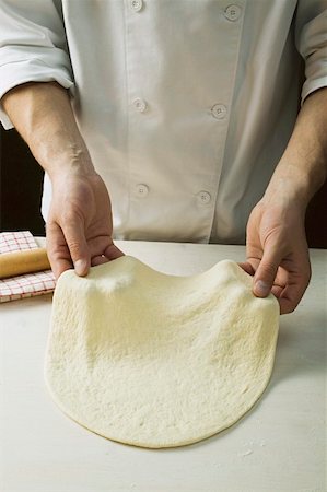 Shaping pizza dough by hand (stretching) Stock Photo - Premium Royalty-Free, Code: 659-01860046