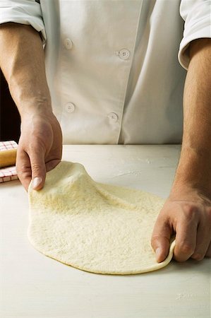 Shaping pizza dough by hand (stretching) Stock Photo - Premium Royalty-Free, Code: 659-01860047