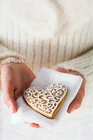 Hands holding gingerbread heart on napkin (Christmassy) Foto de stock - Royalty Free Premium, Número: 659-01860135