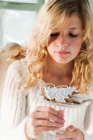 Blond girl holding glass bowl of assorted gingerbread biscuits Foto de stock - Sin royalties Premium, Código: 659-01860141