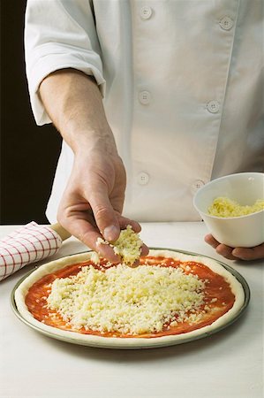 simsearch:659-08903767,k - Sprinkling pizza with cheese Foto de stock - Sin royalties Premium, Código: 659-01860223