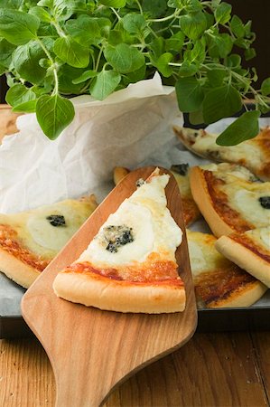 Several slices of American-style three cheese pizza, oregano Foto de stock - Sin royalties Premium, Código: 659-01860281