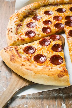 peperoni wurst - American-style pepperoni pizza, a slice cut Stock Photo - Premium Royalty-Free, Code: 659-01860304