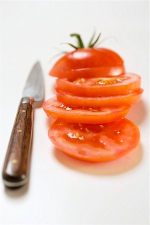 Tomates, coupées en tranches, à côté du couteau Photographie de stock - Premium Libres de Droits, Code: 659-01860482