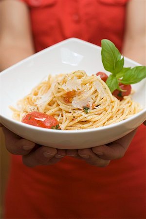 Hands holding plate of spaghetti with Parmesan and basil Stock Photo - Premium Royalty-Free, Code: 659-01860527