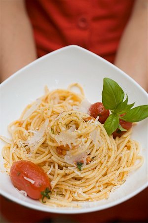 simsearch:659-01857570,k - Hands holding plate of spaghetti with Parmesan and basil Foto de stock - Sin royalties Premium, Código: 659-01860528