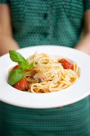 Woman holding plate of spaghetti with Parmesan and basil Foto de stock - Sin royalties Premium, Código: 659-01860531