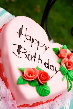 Pink heart-shaped birthday cake on chair in the open air Stock Photo - Premium Royalty-Free, Code: 659-01860629