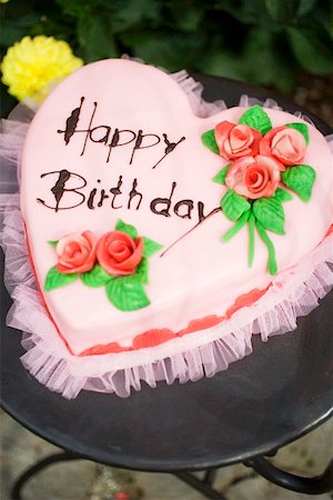 Pink heart-shaped birthday cake on garden table Stock Photo - Premium Royalty-Free, Code: 659-01860632