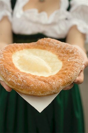 simsearch:659-01860653,k - Woman holding Auszogene (Bavarian fried pastry) on napkin Foto de stock - Sin royalties Premium, Código: 659-01860666