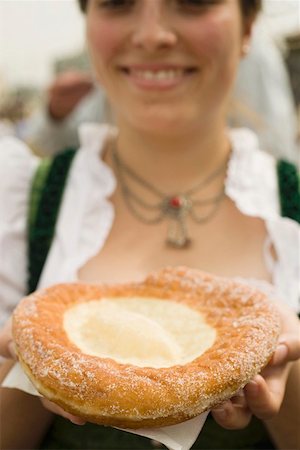 simsearch:659-01860673,k - Woman holding Auszogene (Bavarian fried pastry) on napkin Foto de stock - Sin royalties Premium, Código: 659-01860668
