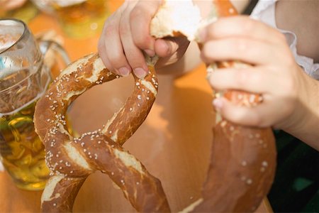 Hands breaking a soft pretzel (Oktoberfest, Munich) Stock Photo - Premium Royalty-Free, Code: 659-01860663