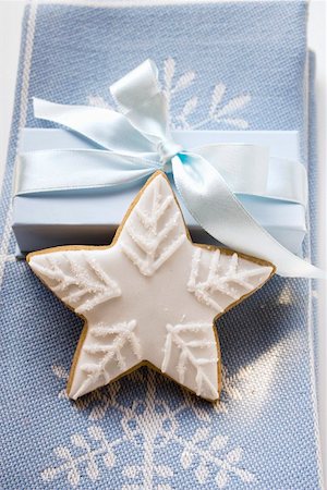 simsearch:659-01860688,k - Gingerbread star with white icing in front of gift Foto de stock - Royalty Free Premium, Número: 659-01860794