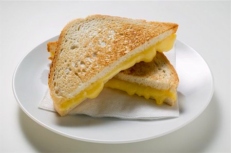 pan tostado - Toasted cheese sandwiches on paper napkin on white plate Foto de stock - Sin royalties Premium, Código: 659-01860935