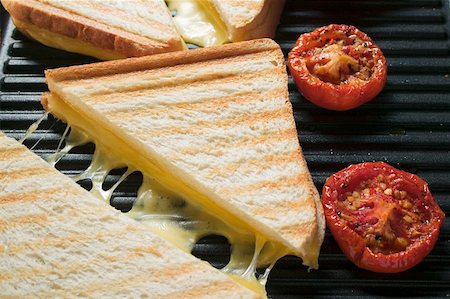 Toasted cheese sandwiches & tomatoes on grill plate (close- up) Stock Photo - Premium Royalty-Free, Code: 659-01860948