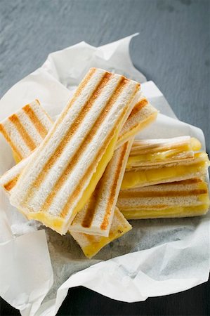 sandwich toast - Several toasted cheese sandwiches on paper Stock Photo - Premium Royalty-Free, Code: 659-01860963