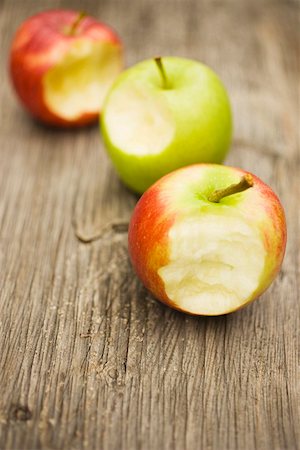 simsearch:659-01861538,k - Three apples with bites taken on wooden background Foto de stock - Sin royalties Premium, Código: 659-01861094