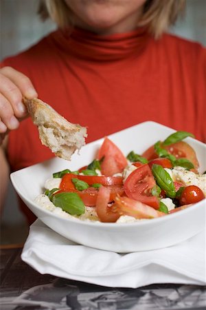 simsearch:659-08148083,k - Woman eating bread with tomatoes, mozzarella and basil Foto de stock - Sin royalties Premium, Código: 659-01861149