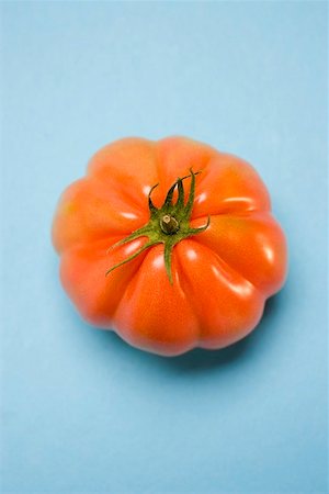 Tomato on pale blue background (overhead view) Stock Photo - Premium Royalty-Free, Code: 659-01861169