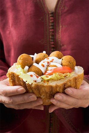 Woman holding flatbread filled with falafel (chick-pea balls) Stock Photo - Premium Royalty-Free, Code: 659-01861432