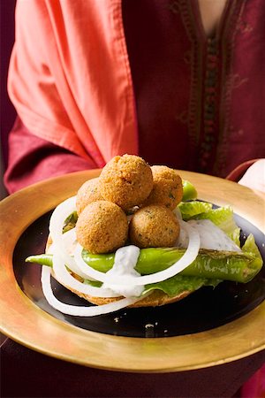 simsearch:659-06495557,k - Woman serving falafel (chick-pea balls) with vegetables Foto de stock - Sin royalties Premium, Código: 659-01861442