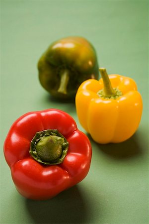 simsearch:659-01861573,k - Three peppers (yellow, red, green) on green background Foto de stock - Sin royalties Premium, Código: 659-01861575