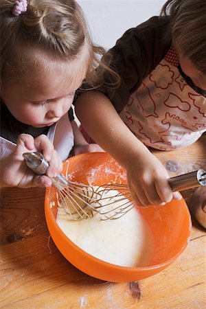 simsearch:649-06433371,k - Deux enfants en remuant le mélange de gâteau avec des fouets Photographie de stock - Premium Libres de Droits, Code: 659-01861759