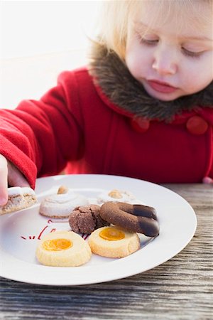 Small girl taking Christmas biscuit from plate Stock Photo - Premium Royalty-Free, Code: 659-01861787