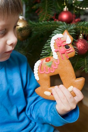 Child holding gingerbread rocking horse in front of Xmas tree Stock Photo - Premium Royalty-Free, Code: 659-01861780