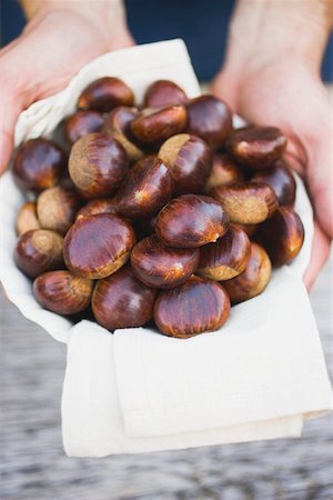 simsearch:659-01861934,k - Hands holding chestnuts on cloth in white bowl Foto de stock - Royalty Free Premium, Número: 659-01861887