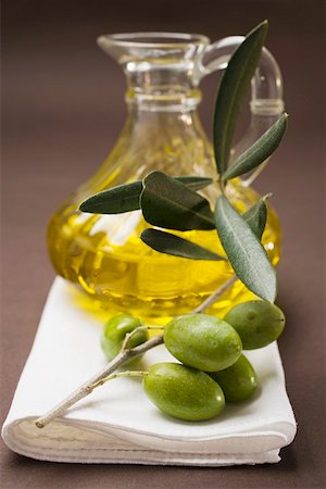 Olive sprig with green olives, carafe of olive oil behind Foto de stock - Sin royalties Premium, Código: 659-01861985