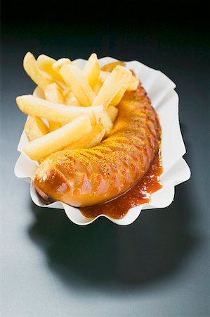 Currywurst (sausage with ketchup & curry powder) & chips on paper dish Stock Photo - Premium Royalty-Free, Code: 659-01862106