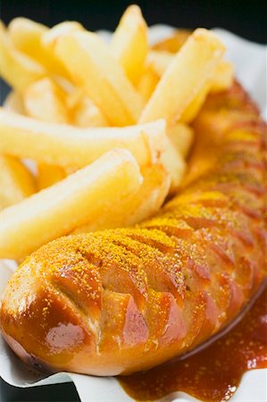 fried sausage - Currywurst (sausage with ketchup & curry powder) & chips (close- up) Stock Photo - Premium Royalty-Free, Code: 659-01862108