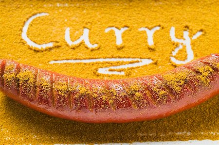 Currywurst und das Wort ""Curry"", geschrieben in Curry-Pulver Stockbilder - Premium RF Lizenzfrei, Bildnummer: 659-01862110