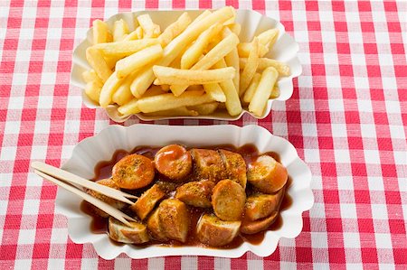 Currywurst (sausage with ketchup & curry powder) with chips Stock Photo - Premium Royalty-Free, Code: 659-01862137