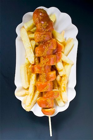 Currywurst (sausage with ketchup & curry powder) & chips in paper dish Stock Photo - Premium Royalty-Free, Code: 659-01862152