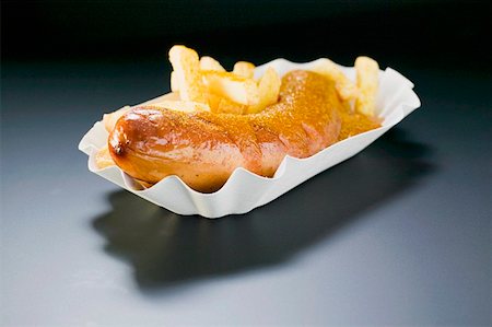 Currywurst (sausage with ketchup & curry powder) & chips on paper dish Stock Photo - Premium Royalty-Free, Code: 659-01862166