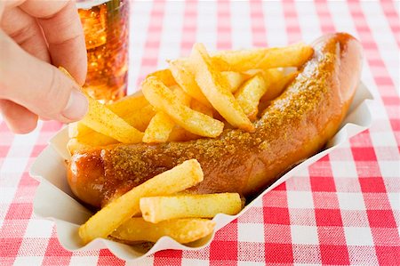 sausage eating - Hand taking chip from paper dish of currywurst and chips Stock Photo - Premium Royalty-Free, Code: 659-01862189