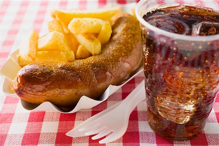 fatty - Sausage with ketchup & curry powder, chips & cola in restaurant Stock Photo - Premium Royalty-Free, Code: 659-01862180