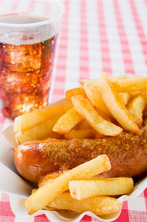 fried sausage - Currywurst (sausage with ketchup & curry powder) in paper dish, cola Stock Photo - Premium Royalty-Free, Code: 659-01862190