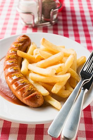 Currywurst (sausage with ketchup & curry powder) & chips in restaurant Stock Photo - Premium Royalty-Free, Code: 659-01862202