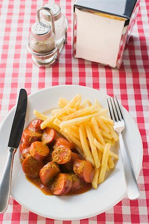 Currywurst (sausage with ketchup & curry powder) & chips in restaurant Stock Photo - Premium Royalty-Free, Code: 659-01862214