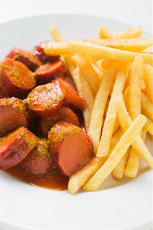 Currywurst (sausage with ketchup & curry powder) & chips on plate Stock Photo - Premium Royalty-Free, Code: 659-01862219